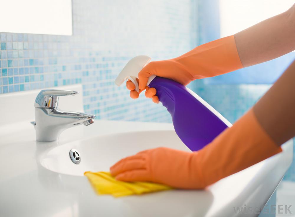 spraying-bathroom-sink-with-cleaner